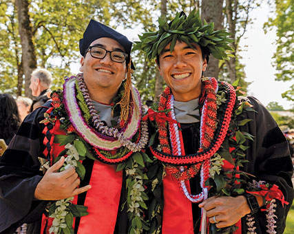 Two graduating students in cap and gown wearing decorations. Links to Donor-Advised Funds